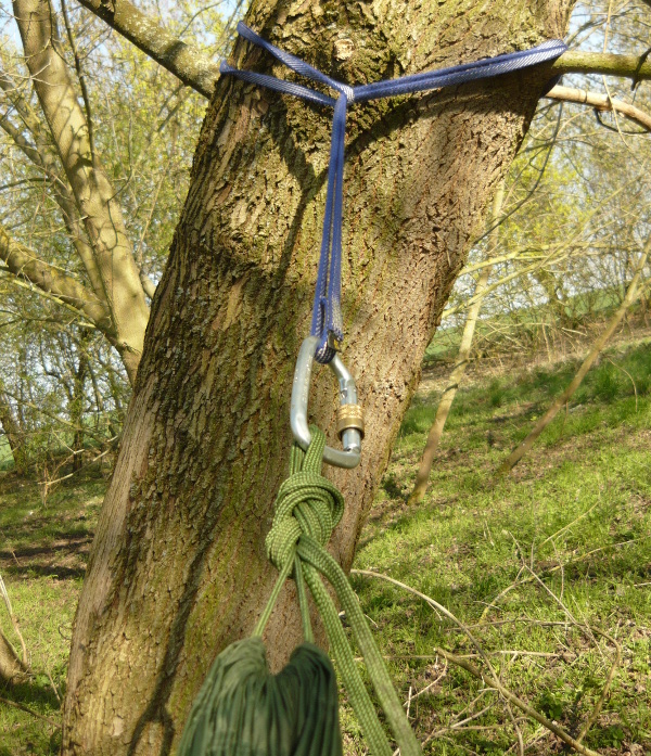 Statt mit den Originalbändern wurde die Hängematte mit  Bandschlinge und Karabiner am Baum befestigt