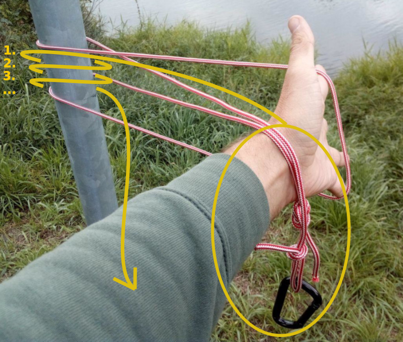 Für den Prussik-Knoten werden die beiden Enden mit dem Karabiner werden so oft durch die Mitte um die Stange gelegt bis genügend Reibung da ist