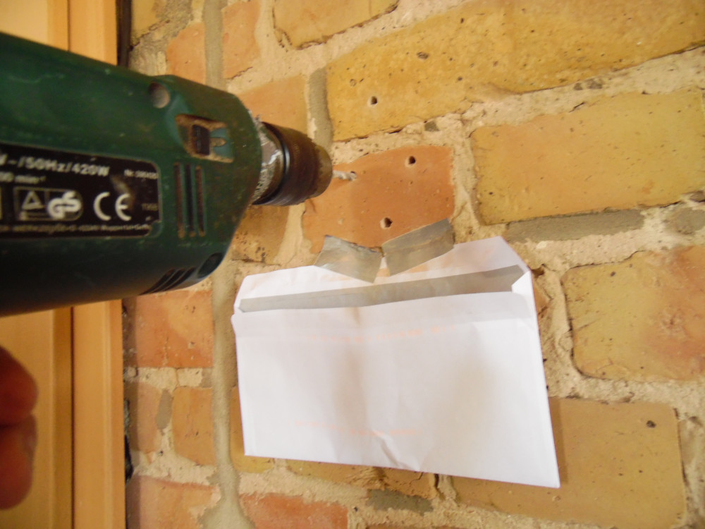Der angeklebte Briefumschlag sammelt den Bohrstaub aus den Bohrlöchern ein